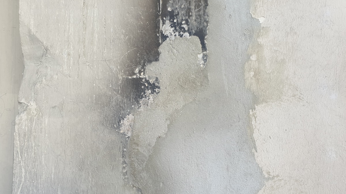 A white wall with peeling paint on it
