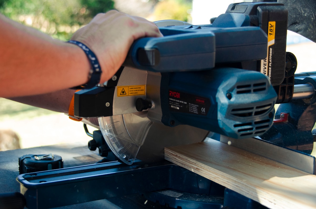 a person using a circular saw to cut a piece of wood